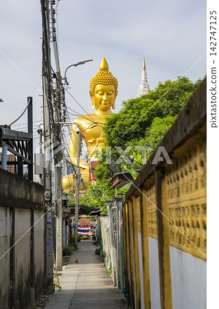 曼谷帕南寺巨大的金色佛像及其後巷的街景。 曼谷帕南寺巨大的金色佛像及其後巷的街景。 142747125