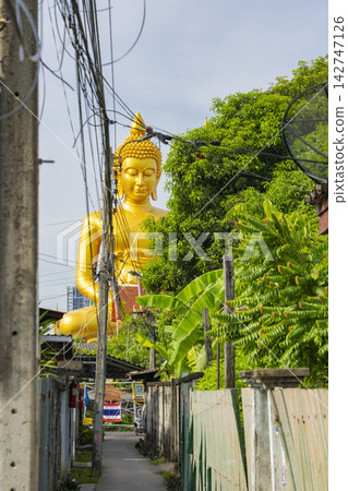 曼谷帕南寺巨大的金色佛像及其後巷的街景。 曼谷帕南寺巨大的金色佛像及其後巷的街景。 142747126