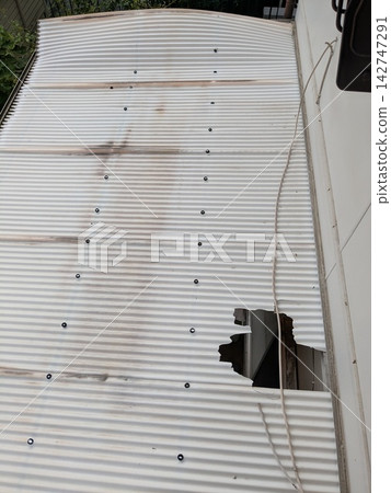 Damaged corrugated roof and large hole: a panoramic view from above 142747291