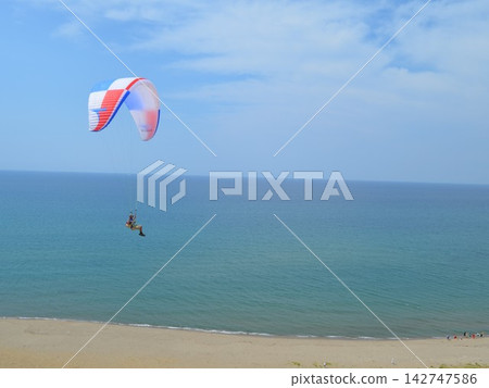 A refreshing scene of paragliders gliding above the seashore. A refreshing scene of paragliders gliding above the seashore. 142747586