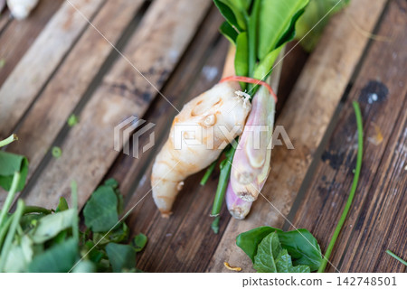 Fresh galangal root lemongrass bundled green aromatic leaves rustic wood representing traditional Thai cooking ingredients natural Asian herbs Fresh galangal root lemongrass bundled green aromatic leaves rustic wood representing traditional Thai cooking ingredients natural Asian herbs 142748501