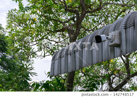 Outdoor surveillance camera mounted property entrance structure surrounded by green trees for home security monitoring safety protection access control Outdoor surveillance camera mounted property entrance structure surrounded by green trees for home security monitoring safety protection access control 142748517