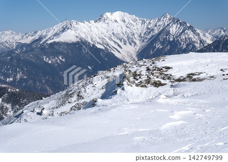 白雪皚皚的穗高山脈和壯麗的北阿爾卑斯山自然風光在晴朗明亮的天空下巍然聳立。 白雪皚皚的穗高山脈和壯麗的北阿爾卑斯山自然風光在晴朗明亮的天空下巍然聳立。 142749799