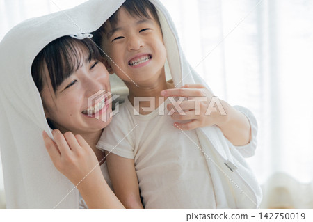 Mom and child wiping their heads with a white towel Mom and child wiping their heads with a white towel 142750019