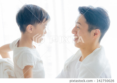 A father dries his child with a towel after their bath. A father dries his child with a towel after their bath. 142750026