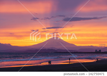 Shonan Kugenuma Beach: Mt. Fuji, sunset sky, and silhouettes of people. Shonan Kugenuma Beach: Mt. Fuji, sunset sky, and silhouettes of people. 142750471