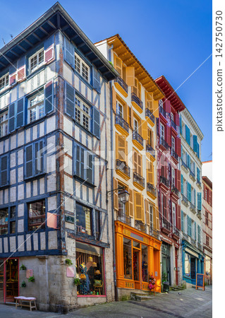 Historical Basque houses with bright colorful window shutters on a street in Bayonne, France. Sunny daylight view, no people Historical Basque houses with bright colorful window shutters on a street in Bayonne, France. Sunny daylight view, no people 142750730