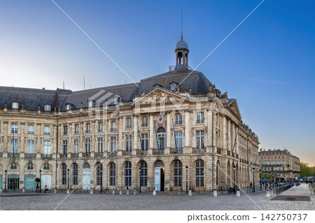 Classical facade of the right wing at Place de la Bourse in Bordeaux, France. Bright daylight highlights historic limestone Classical facade of the right wing at Place de la Bourse in Bordeaux, France. Bright daylight highlights historic limestone 142750737