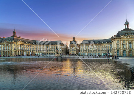 Panoramic view of Place de la Bourse with the central fountain under a sunset sky in Bordeaux, France. Elegant historic palace Panoramic view of Place de la Bourse with the central fountain under a sunset sky in Bordeaux, France. Elegant historic palace 142750738
