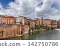View of old brick houses on the opposite bank of Tarn river in Albi, France. Historic urban architecture under sky 142750786