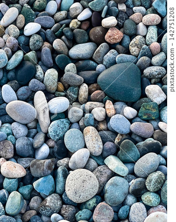 Colorful Stones Scattered on a Beach Near the Water During the Daytime in a Coastal Area Colorful Stones Scattered on a Beach Near the Water During the Daytime in a Coastal Area 142751208