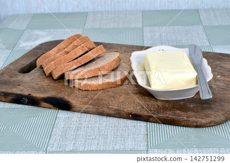 There is bread and butter on the table. There is bread and butter on the table. 142751299