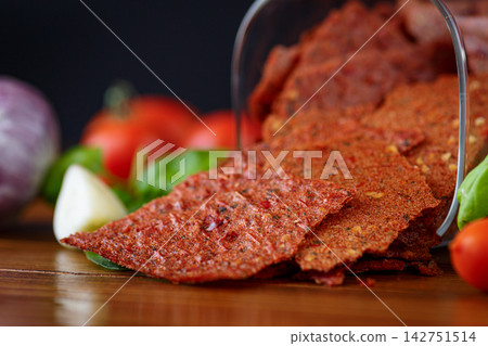 Homemade dried tomato pastila with herbs on rustic table Homemade dried tomato pastila with herbs on rustic table 142751514