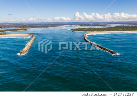 Description: Aerial view of the Clarence River flowing between the Yamba and Iluka breakwalls at the river entrance on the Northern Rivers coast of New South Wales, Australia. 142752227