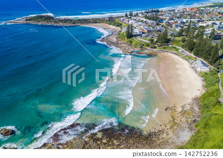 Aerial view of Yamba Main Beach and Yamba Ocean Pool along the rocky coastline, with Lovers Point and the Yamba township visible in the background in northern New South Wales, Australia. Aerial view of Yamba Main Beach and Yamba Ocean Pool along the rocky coastline, with Lovers Point and the Yamba township visible in the background in northern New South Wales, Australia. 142752236