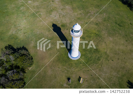 Aerial view of Yamba Lighthouse standing on Pilot Hill, surrounded by coastal vegetation and overlooking the Yamba coastline in northern New South Wales, Australia. Aerial view of Yamba Lighthouse standing on Pilot Hill, surrounded by coastal vegetation and overlooking the Yamba coastline in northern New South Wales, Australia. 142752238