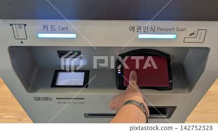 The hand scanning the passport at the airport ticket machine. The hand scanning the passport at the airport ticket machine. 142752328