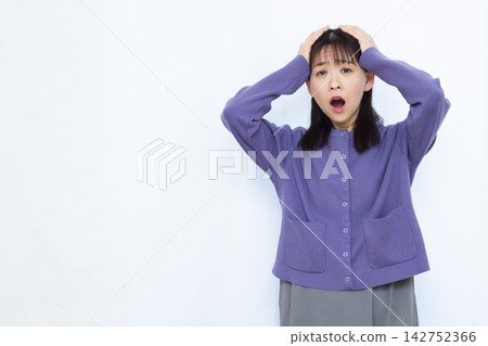 A woman with her head in her hands, looking pale. A woman with her head in her hands, looking pale. 142752366