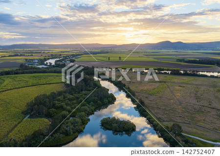 Aerial view over the Clarence River and surrounding farmland, with soft clouds and sky reflected across the calm water in northern New South Wales, Australia. Aerial view over the Clarence River and surrounding farmland, with soft clouds and sky reflected across the calm water in northern New South Wales, Australia. 142752407