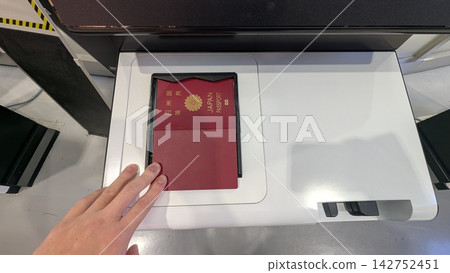 A hand scanning a passport at an automated check-in machine at Narita Airport. A hand scanning a passport at an automated check-in machine at Narita Airport. 142752451