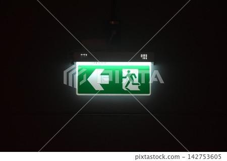close up of green electric light box sign fire exit door on wall in black background close up of green electric light box sign fire exit door on wall in black background 142753605
