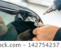 A car wrapping specialist applies a polyurethane film to the car. Detailer PPF 142754237