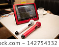 Two microphones and a song selection tablet were placed on the table in the karaoke room. 142754332