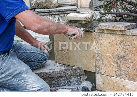 Masonry Worker Applying Repair Mortar with Trowel Masonry Worker Applying Repair Mortar with Trowel 142754415