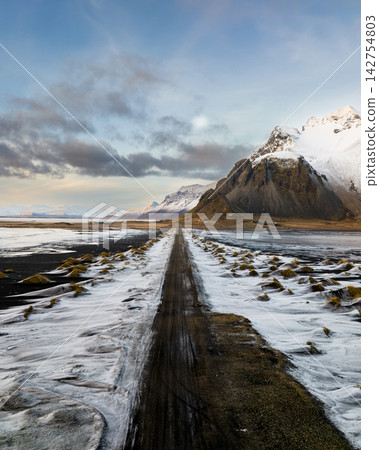 Snow-covered Vestrahorn mountain and icy landscape at Stokksnes beach, South East Iceland Snow-covered Vestrahorn mountain and icy landscape at Stokksnes beach, South East Iceland 142754803