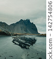 Reflection of Vestrahorn mountain in a water pool on Stokksnes beach, South East Iceland 142754806