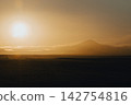 Golden sunrise over Hekla volcano in South Iceland, creating a serene landscape. 142754816