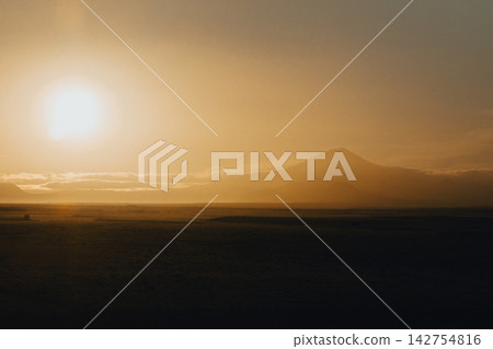 Golden sunrise over Hekla volcano in South Iceland, creating a serene landscape. Golden sunrise over Hekla volcano in South Iceland, creating a serene landscape. 142754816