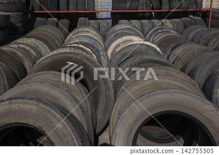 Stack of old car tires in recycling facility 142755305