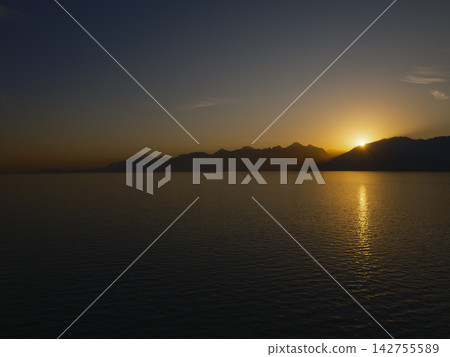 Scenic sunset view with mountains and serene ocean Scenic sunset view with mountains and serene ocean 142755589