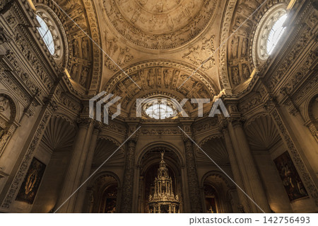 Ornate dome ceiling with oval oculus windows above a golden monstrance in Seville Cathedral Ornate dome ceiling with oval oculus windows above a golden monstrance in Seville Cathedral 142756493