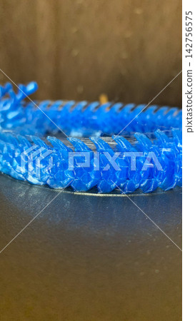 Macro focus on an abstract blue 3D printed mechanical spine structure showcasing intricate geometric textures and layered plastic surfaces Macro focus on an abstract blue 3D printed mechanical spine structure showcasing intricate geometric textures and layered plastic surfaces 142756575