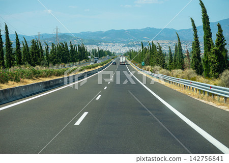 Empty asphalt highway road stretching through a scenic green valley landscape Empty asphalt highway road stretching through a scenic green valley landscape 142756841