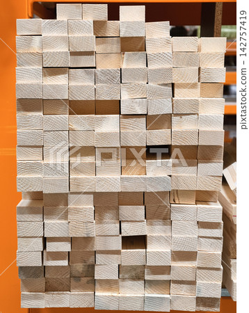 Boards, wooden slats, timber planks and other wood products stored on metal shelves in a construction supermarket Boards, wooden slats, timber planks and other wood products stored on metal shelves in a construction supermarket 142757419