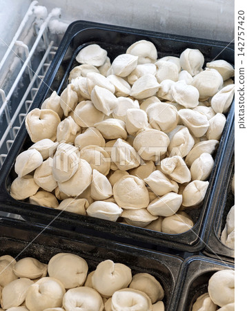 Dumplings kept frozen in a supermarket refrigerator are convenient semi finished foods suitable for simple home cooking Dumplings kept frozen in a supermarket refrigerator are convenient semi finished foods suitable for simple home cooking 142757420