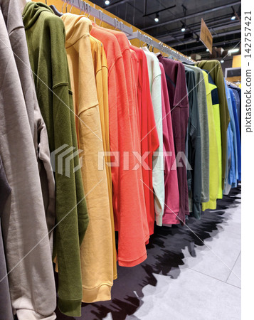 Multicolored hoodies on racks in a sports shop present a wide range of comfortable apparel for active lifestyle Multicolored hoodies on racks in a sports shop present a wide range of comfortable apparel for active lifestyle 142757421