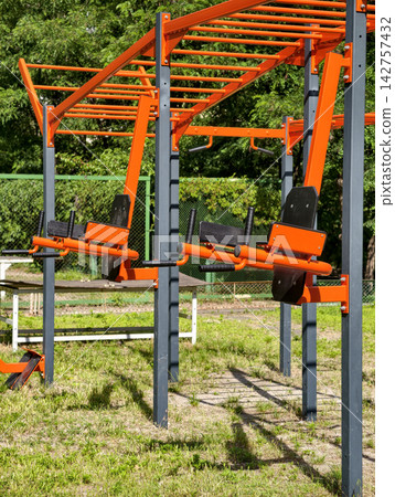 Metal outdoor workout equipment at a public fitness area in a residential courtyard for sports training and physical development Metal outdoor workout equipment at a public fitness area in a residential courtyard for sports training and physical development 142757432