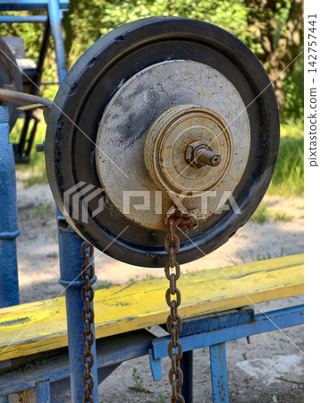 Classic barbell setup with rubber and iron weight plates on a yellow flat bench at an outdoor training area for chest muscle exercises and fitness workouts Classic barbell setup with rubber and iron weight plates on a yellow flat bench at an outdoor training area for chest muscle exercises and fitness workouts 142757441