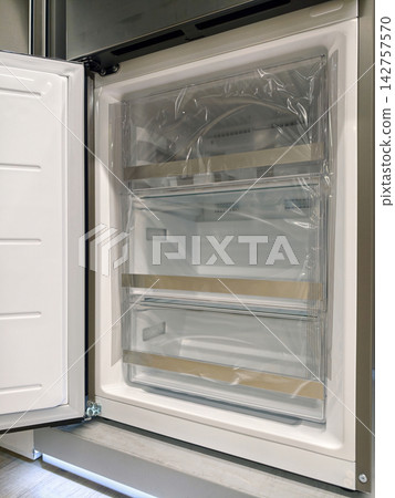 Premium fridge with open freezer door, available for sale in a home appliance mall Premium fridge with open freezer door, available for sale in a home appliance mall 142757570