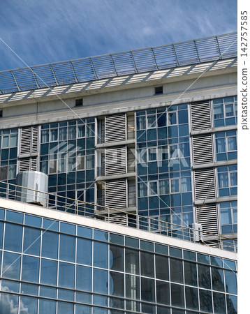 Urban apartment skyscraper with modern windows and balconies in a densely populated neighborhood Urban apartment skyscraper with modern windows and balconies in a densely populated neighborhood 142757585