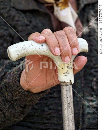 Elderly woman hand resting on a walking cane highlighting age support stability and daily mobility in a close detail suitable for healthcare and senior care concepts Elderly woman hand resting on a walking cane highlighting age support stability and daily mobility in a close detail suitable for healthcare and senior care concepts 142757643
