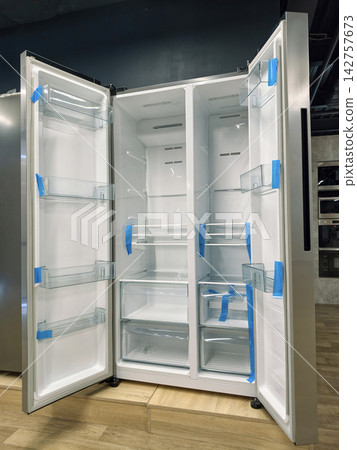 Double-door refrigerator with both doors open, offering a clean and organized interior for your food Double-door refrigerator with both doors open, offering a clean and organized interior for your food 142757673