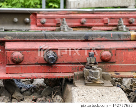 Red track clamp holds rail pad in place for proper signaling and control. Insulating pad is used at joints to electrically isolate rails, which is important for signaling and train control systems 142757683