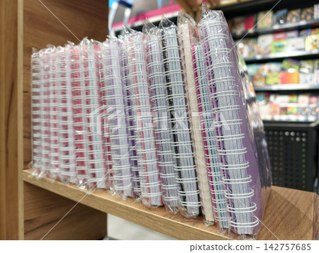 Shop display shows colorful softcover spiral notebooks neatly arranged in stationery store Shop display shows colorful softcover spiral notebooks neatly arranged in stationery store 142757685