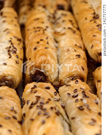 Fresh long rolini pastries with a round tube shape and filling inside presented in a bakery, showcasing sweet baked products arranged for customers and shoppers Fresh long rolini pastries with a round tube shape and filling inside presented in a bakery, showcasing sweet baked products arranged for customers and shoppers 142757775