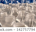 Mineral water bottles in plastic containers are tightly sealed with transparent polyethylene film, showing packaged drinking water grouped together 142757794